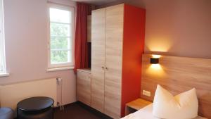 a hotel room with a bed and a cabinet at Familienferienpark Dambeck in Kratzeburg