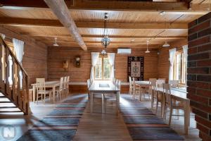 une salle à manger avec des murs en bois, des tables et des chaises dans l'établissement Nelikko juhla- ja majoitustilat, à Himanka