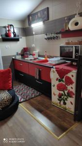 a kitchen with a red counter and a microwave at Studio Madi - Close to beach in Constanţa