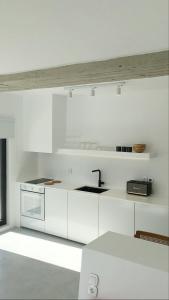 a white kitchen with white cabinets and a sink at AESIS in Krokos