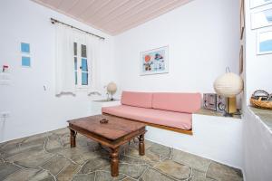 a living room with a pink couch and a table at Lighthouse Hotel in Faros