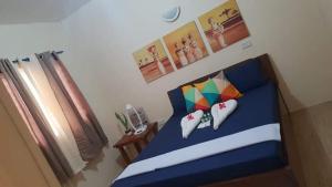 a bedroom with a blue bed and a window at House Rental Banaba Tree in Samboan
