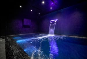 a swimming pool with a water fountain in a room at H Hotel & SPA - Adults Only in St. Julianʼs