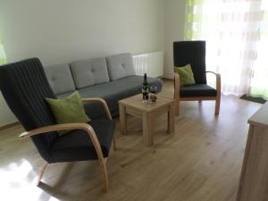 sala de estar con sofá, 2 sillas y mesa en Lakóparki Apartman, en Veszprém