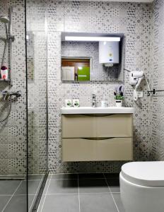 a bathroom with a toilet and a sink and a shower at Beachfront, Tirana Guest House in Velipojë