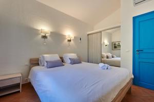 a bedroom with a large white bed with two pillows at Résidence Belvedere de Palombaggia in Porto-Vecchio
