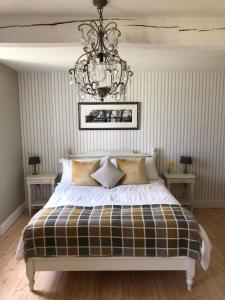 a bedroom with a bed with a chandelier at Le Pigeonnier Gite in Verrières