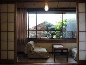 a room with a chair and a large window at Tsubakiso in Nara