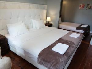 a hotel room with a large white bed and a chair at Casa Azul Hostel in Sintra