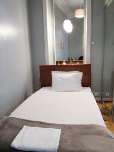a white bed in a room with a mirror at Casa Azul Hostel in Sintra