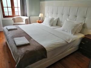a large white bed in a room with a chair at Casa Azul Hostel in Sintra