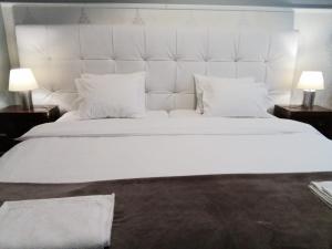 a bedroom with a large white bed with two lamps at Casa Azul Hostel in Sintra