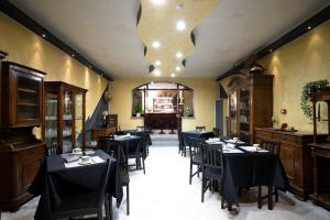 ein Esszimmer mit Tischen und Stühlen und einem Kronleuchter in der Unterkunft J Hotel in Orbassano
