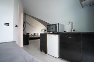 a kitchen with a bed and a microwave on a counter at J Hotel in Orbassano