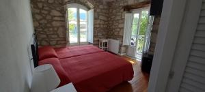 um quarto com uma cama vermelha num quarto com janelas em HOSTERÍA SEÑORÍO DE BIZKAIA em Bakio