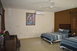 sypialnia z 2 łóżkami i wentylatorem sufitowym w obiekcie Hotel D’Cural w mieście Oxkutzcab