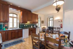 a kitchen with wooden cabinets and a table in a room at Quinta do Americano in Sardoal