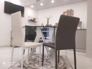 two white chairs and a glass table in a room at Vernazza Luxury Apartment in Vernazza