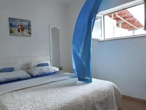 a bedroom with a bed with a blue tent over it at Apartmani Leženić Dada in Neum