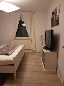 um quarto com uma cama e uma televisão num armário em schöne Ferienwohnung am Rande der Altstadt em Lutherstadt Wittenberg