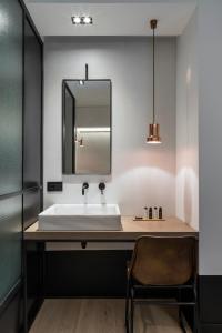 a bathroom with a sink and a mirror at Niki Athens Hotel in Athens