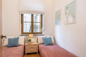 salon z dwoma łóżkami i oknem w obiekcie Home Sweet Home w Krakowie