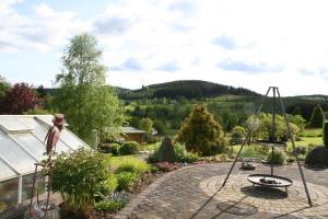 a garden with a statue and a swing at Fewo Röspe in Erndtebrück