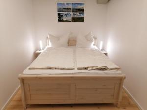 een groot bed met witte lakens en kussens erop bij Speicher Residenz Barth E2 App 3 in Barth