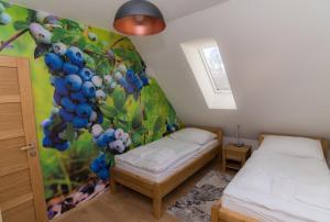 a bedroom with two beds and a mural of grapes at Chalupa pod bukom in Predná Hora