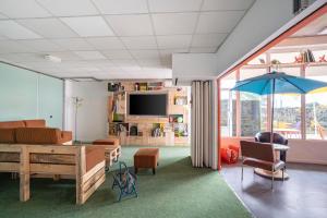 a living room with a table and a blue umbrella at greet Hotel Bordeaux Aeroport in Mérignac