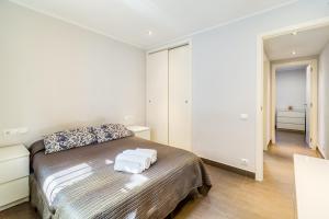 a bedroom with a bed with two towels on it at Hauzify I Apartament Edelweiss in Platja  d'Aro