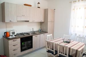 cocina con mesa, fregadero y fogones en Appartamenti DeSi, en Tropea