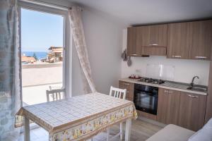 une cuisine avec une table et une vue sur l'océan dans l'établissement Appartamenti DeSi, à Tropea