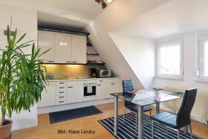 a kitchen with white cabinets and a dining room table at Domizil Domblick Speyer City, Garage, 50m2 in Speyer