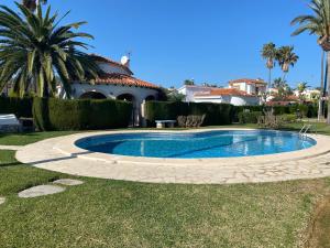 une piscine devant une maison dans l'établissement Adosado de lujo en Olivanova Golf con 3 dormitorios, à Oliva