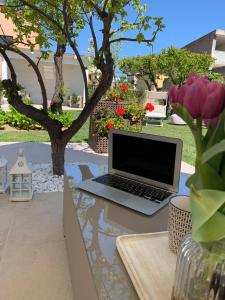 奧爾比亞的住宿－Enjoy Your Stay - Guest House - Olbia，坐在花园里桌子上的笔记本电脑