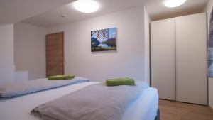 2 letti in una camera con pareti bianche di DAS JOHANN Apartments im Ausseerland a Bad Aussee