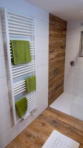 a bathroom with a shower with green towels at DAS JOHANN Apartments im Ausseerland in Bad Aussee +73 photos