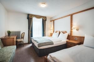 Un pat sau paturi într-o cameră la Hotel B&B Frohsinn
