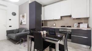 eine Küche und ein Esszimmer mit einem Tisch und einem Sofa in der Unterkunft Italianway - Marcantonio dal Re 20 C in Mailand