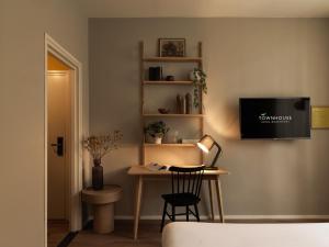Zimmer mit einem Schreibtisch und einem TV an der Wand in der Unterkunft Townhouse Apartments Maastricht in Maastricht