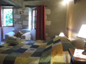 1 dormitorio con 1 cama y 1 mesa con lámpara en La Closerie, en Saint-Philbert-du-Peuple