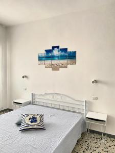 una camera da letto con un letto con tre dipinti sul muro di Casa Puntamare a Peschici