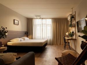 ein Hotelzimmer mit einem Bett und einer Couch in der Unterkunft Townhouse Apartments Maastricht in Maastricht