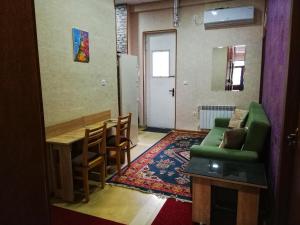 a living room with a green couch and a table at Hostel Violet in Tbilisi City