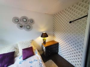 a bedroom with a bed and a table with a lamp at FLOREVA 43 Proche plage et thalasso in Concarneau