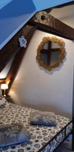 1 dormitorio con 1 cama con espejo en la pared en LE CHALET SUISS - Chambre Santorin en Le Vicel