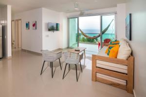 ein Wohnzimmer mit einer Couch und einem Tisch und Stühlen in der Unterkunft Magico Apartamento Frente al Mar 3 Habitaciones AR44 in Coveñas