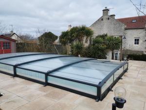 a large blue swimming pool on a patio at Normandie, mer et campagne in Ver-sur-Mer