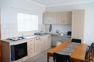 a kitchen with a wooden table and a table and a dining room at The Nook in Cradock